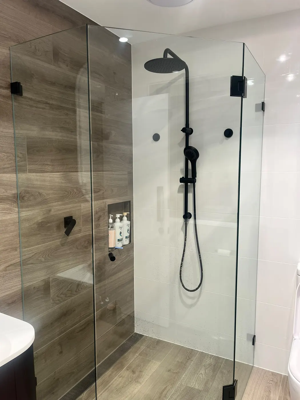 Frameless shower with matte black tapware